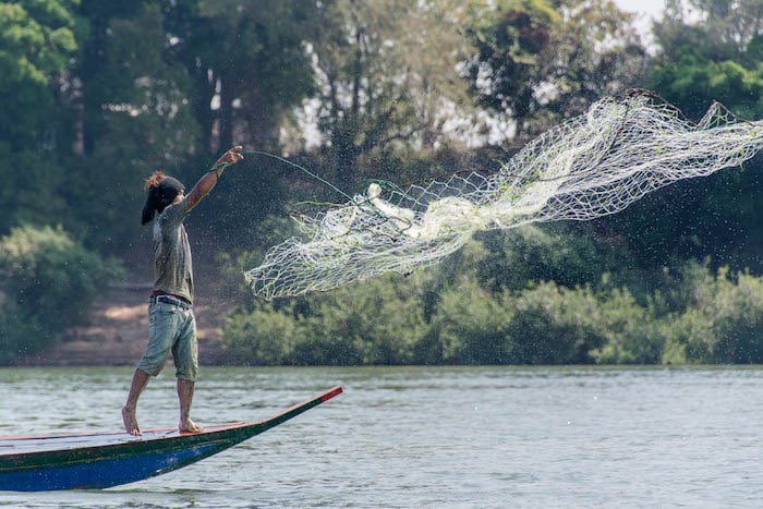 Mekong River, Koh Rongeav island, Kratie Province, Cambodia. A fisherman throws his cast net into the Mekong River in an area populated by Irrawaddy dolphins. A hydropower dam is scheduled to submerge this area of islands. Photo credit: RodHarbinson.com